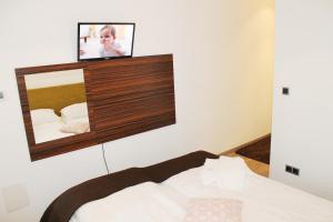 a room with a bed with a tv on the wall at Silver Mountain Apartment A32 - 3 rooms 3 bathrooms in Poiana Brasov +22 photos