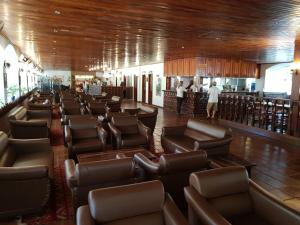 una sala d'attesa con sedie in pelle e un bar di Hotel Cavalinho Branco Flat Service 615 ad Águas de Lindóia