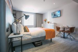 1 dormitorio con cama, mesa y escritorio en Grafton Street Studios by City Break Apartments en Dublín