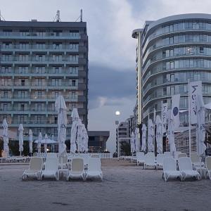 plaża z leżakami i parasolami oraz budynek w obiekcie SummerHouse Apartments w Mamai