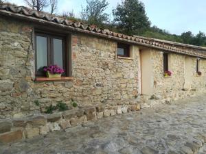 a stone house with a window and flowers on it at Il Cerro Agriturismo Zagarese in Fuscaldo