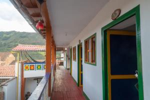 a corridor of a building with a door and a balcony at Hostal El Caminante in El Cocuy