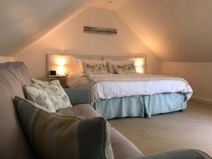 a bedroom with a large bed and a chair at Windrush Apartment in Witney