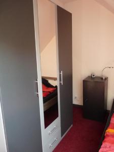 1 dormitorio con armario con espejo y cama en gemütliche Ferienwohnung, en Düsseldorf