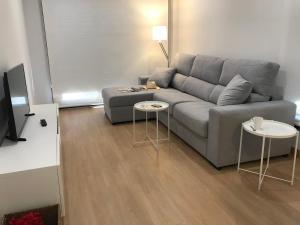 uma sala de estar com um sofá e duas mesas em Apartamentos Areas em Sanxenxo