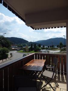 a table and chairs on a balcony with a view of a street at Gîte du Lac in Gérardmer