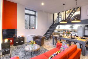 a living room with orange furniture and a staircase at Academy's Loft in Dijon +16 photos