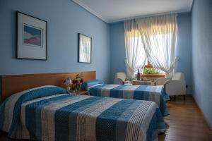 2 camas en una habitación con paredes azules en Casa Pichon Etxea, en Lapuebla de Labarca