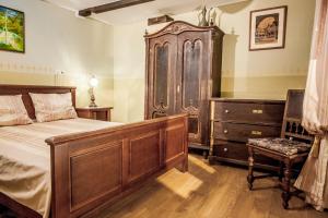 a bedroom with a large bed and a wooden dresser at Country house with a pool in Medvednica Nature Park in Zagreb