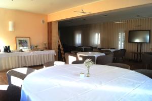 uma sala de conferências com mesas e cadeiras e uma televisão em Pousada Conde de Ourém em Ourém