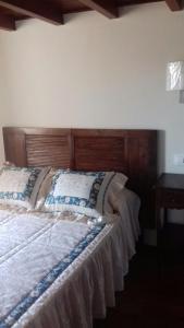 a bed with a wooden headboard in a bedroom at Casa Lola in Villastose