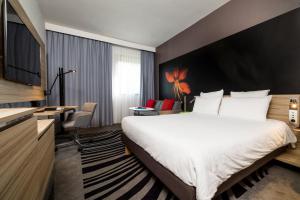 a hotel room with a large bed and a large window at Novotel Milano Linate Aeroporto in Milan