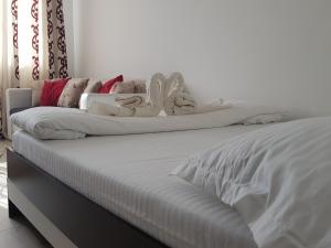 a white bed with white sheets and pillows on it at Studio Central in Piatra Neamţ