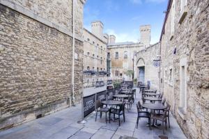 a row of tables and chairs in an alley at Oxfordshire Living - The Monroe Apartment - Oxford in Oxford