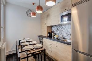 a kitchen with a group of stools around a table at Fee4Me Marques Vintage Apartment in Madrid