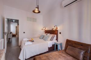 マドリードにあるFee4Me Marques Vintage Apartmentの白いベッドルーム(ベッド1台、ソファ付)