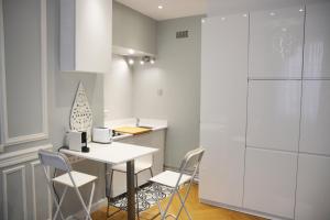 a kitchen with a table and chairs and a refrigerator at Residence sur Cour in Paris