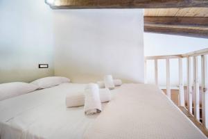 a bedroom with a white bed with towels on it at Kyriaki's Traditional Loft in Galatás