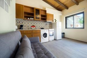 a living room with a couch and a kitchen at Kyriaki's Traditional Loft in Galatás