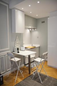 uma cozinha com mesa e cadeiras num quarto em Residence sur Cour em Paris