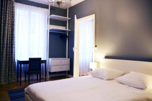 a bedroom with a bed and a chair and a desk at Residence sur Cour in Paris