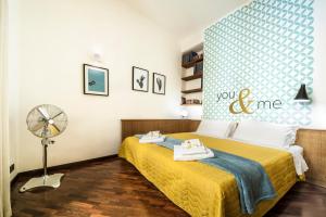 a bedroom with a yellow bed and a fan at Rome As You Feel - Baccina 95 Forum Apartment in Rome