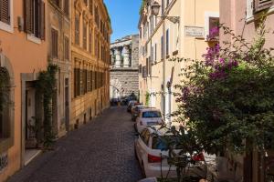 a narrow street with cars parked on the side at Rome As You Feel - Baccina 95 Forum Apartment in Rome