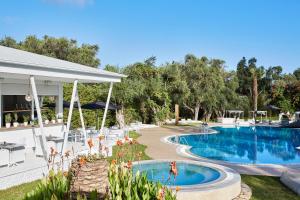 a swimming pool with chairs and a pavilion at Mr and Mrs White Corfu Couples Retreat Adults Only in Acharavi