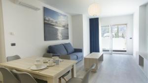 uma sala de estar com uma mesa e um sofá azul em Piamarta Apartments em Toscolano Maderno