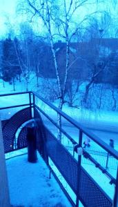 a bench covered in snow next to a fence at AMBER Hotel & Cafe in Bohorodchany