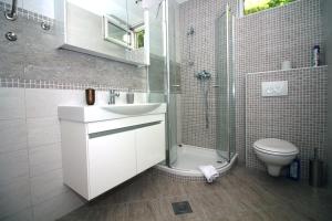 a bathroom with a sink and a shower and a toilet at Apartmani TEO in Tisno +67 photos