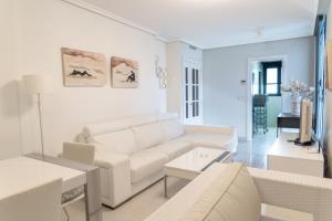 a white living room with a couch and a table at Gemelos 26 - Beninter All Inclusive in Benidorm