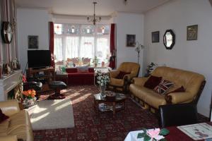 a living room with couches and a tv at The Lyndsay Guest House in Skegness