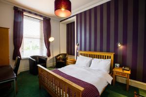 een hotelkamer met een bed en een stoel bij Inn At The Park Hotel in Aberdeen