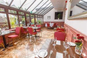 a dining room with tables and chairs and windows at Inn At The Park Hotel in Aberdeen