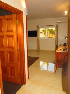Habitación con escritorio, mesa y puerta en Hotel Castelo Branco, en Chimoio
