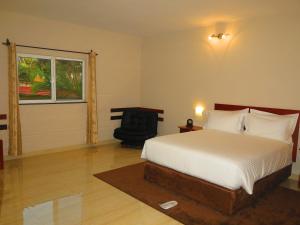 1 dormitorio con 1 cama, 1 silla y 1 ventana en Hotel Castelo Branco, en Chimoio