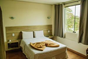 a bedroom with a bed with a blanket on it at Dalle Hotel in Bagé