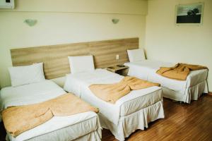 a room with two beds with blankets on them at Dalle Hotel in Bagé