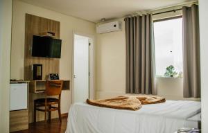 a bedroom with a bed with a blanket on it at Dalle Hotel in Bagé