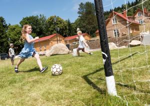 two children playing with a soccer ball in a field at Das Schierke Harzresort in Schierke