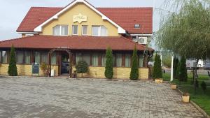 a large yellow building with a red roof at Royal 60 in Oşorheiu