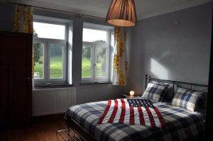 a bedroom with a bed with an american flag on it at Santa Fe - Lutrebois in Bastogne