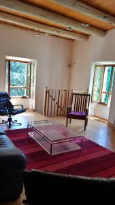 Gite Le Moulin de Rosieres Moulin Champetier في Rosières: غرفة معيشة مع طاولة وكراسي زجاجية +23 صورة