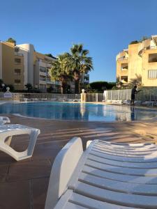 ein großer Pool mit einer weißen Bank in einem Gebäude in der Unterkunft Front beach Luxury near Nice airport in Cagnes-sur-Mer