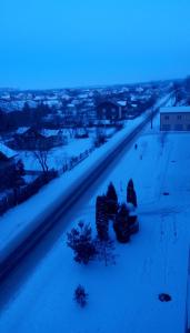 a snow covered road with a city in the distance at AMBER Hotel & Cafe in Bohorodchany