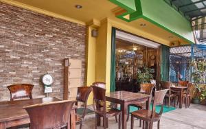un restaurante con mesas y sillas y una pared de ladrillo en Twins Hotel, en Yakarta
