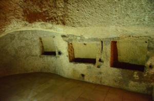 una camera con tre finestre in un muro di pietra di Baja delle Sirene a Taranto