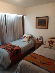 a bedroom with two beds and a window at La Maison in San Fernando del Valle de Catamarca +5 photos