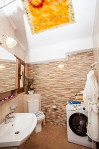 een badkamer met een wastafel en een wasmachine bij Afroditi in Rethimnon